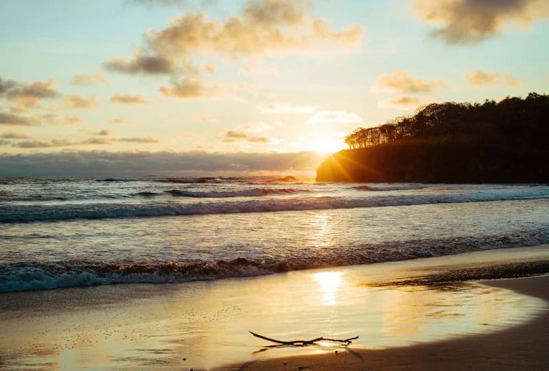Golden sunset over Playa Grande beach in Costa Rica with waves rolling onto the shore, capturing a peaceful digital detox setting